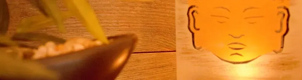 Bougie allumée devant une statue de Bouddha, ambiance zen