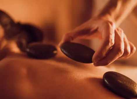Pose de pierres volcaniques chaudes sur le dos pendant un massage