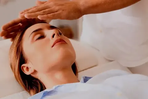 Soin reiki par imposition des mains sur une personne allongée